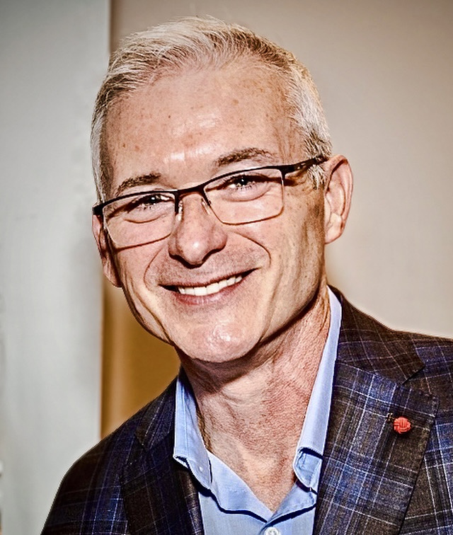 Chuck Doud smiling in a suit jacket